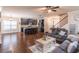 Inviting open-concept living room with dark wood floors flowing into a kitchen with island and modern appliances at 486 Raven Brook Ln, Suwanee, GA 30024