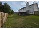 A spacious backyard featuring a wooden fence, green grass, and a small wooden deck at 6948 Dalehollow Dr, Lithonia, GA 30058