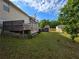 Backyard with large grassy area, wooden deck, fence, and mature trees at 6948 Dalehollow Dr, Lithonia, GA 30058