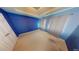 Spacious bedroom with light carpet, a blue accent wall, and a high trey ceiling at 6948 Dalehollow Dr, Lithonia, GA 30058