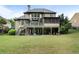 Expansive backyard with a multi-level deck, lush lawn, and mature trees offering shade and privacy at 1062 Meadow Grass Ln, Powder Springs, GA 30127