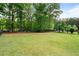 Expansive backyard with lush green grass and ample space for recreation, surrounded by mature trees at 1062 Meadow Grass Ln, Powder Springs, GA 30127