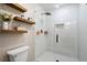 Contemporary bathroom with a glass-enclosed shower, rainfall showerhead, and stylish shelving for storage at 1062 Meadow Grass Ln, Powder Springs, GA 30127