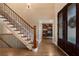 Open foyer featuring hardwood floors, a staircase with iron railings, and a view into a study with custom shelving at 1062 Meadow Grass Ln, Powder Springs, GA 30127