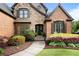 Close-up of a home's inviting front entrance, featuring stone accents, a walkway, and colorful landscaping at 1062 Meadow Grass Ln, Powder Springs, GA 30127