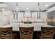 Large kitchen island with white marble countertop and pendant lights in a modern kitchen at 1062 Meadow Grass Ln, Powder Springs, GA 30127