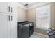 Well-organized laundry room with modern washer and dryer, ample storage cabinets, and stylish patterned flooring at 1062 Meadow Grass Ln, Powder Springs, GA 30127