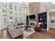 Open living room with stone fireplace, high ceilings, and wall of bright windows at 1062 Meadow Grass Ln, Powder Springs, GA 30127