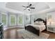 Spacious main bedroom with tray ceilings, large windows, hardwood floors, and a ceiling fan at 1062 Meadow Grass Ln, Powder Springs, GA 30127