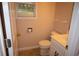 Small bathroom with a white toilet and white sink next to a window at 1120 Lake Lucerne Rd, Lilburn, GA 30047
