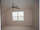 Comfortable bedroom with neutral carpet, ceiling fan, and a bright window at 1120 Lake Lucerne Rd, Lilburn, GA 30047