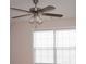 A ceiling fan with lights hangs over a window with blinds in a bedroom at 1120 Lake Lucerne Rd, Lilburn, GA 30047