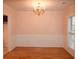 Bright dining room featuring classic hardwood floors, a modern chandelier, and tasteful wainscoting for an elegant touch at 1120 Lake Lucerne Rd, Lilburn, GA 30047