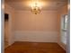 Bright dining room featuring classic hardwood floors, a modern chandelier, and tasteful wainscoting for an elegant touch at 1120 Lake Lucerne Rd, Lilburn, GA 30047