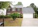 Charming two-story red brick home with a two-car garage and a well-manicured lawn at 1120 Lake Lucerne Rd, Lilburn, GA 30047