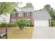 Charming two-story red brick home with a two-car garage and a well-manicured lawn at 1120 Lake Lucerne Rd, Lilburn, GA 30047