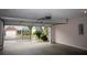 View of the garage looking out onto the yard, with a clean concrete floor and white walls at 1120 Lake Lucerne Rd, Lilburn, GA 30047
