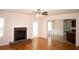 Bright living room featuring hardwood floors, a brick fireplace, and an open doorway to the kitchen at 1120 Lake Lucerne Rd, Lilburn, GA 30047
