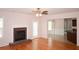 Bright living room featuring hardwood floors, a brick fireplace, and an open doorway to the kitchen at 1120 Lake Lucerne Rd, Lilburn, GA 30047