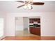 Bright living room featuring hardwood floors, a ceiling fan, and a view into the kitchen and dining area at 1120 Lake Lucerne Rd, Lilburn, GA 30047