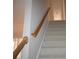 Carpeted staircase with wood railing leads to the upper level of the home at 1120 Lake Lucerne Rd, Lilburn, GA 30047