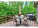 Enjoy the outdoors on the deck featuring a patio table, chairs, grill, and wooded views at 2253 Creekstone Ct, Marietta, GA 30062