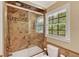 Remodeled bath featuring a tub with shower and glass door at 2253 Creekstone Ct, Marietta, GA 30062