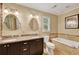 Bright bathroom features double vanity, granite countertop, soaking tub with tile surround, and neutral paint at 2253 Creekstone Ct, Marietta, GA 30062