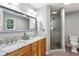Well-lit bathroom boasting a granite countertop, double sinks, and a glass-enclosed shower at 230 Seamarsh Ct, Atlanta, GA 30328