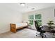 Cozy bedroom featuring a wooden bed frame and desk, bathed in natural light at 230 Seamarsh Ct, Atlanta, GA 30328