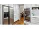 Kitchen area with stainless steel refrigerator and oven; hardwood floors extend into the connecting dining area at 230 Seamarsh Ct, Atlanta, GA 30328