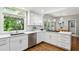 Open kitchen area filled with natural light boasting stainless steel appliances and white cabinets at 230 Seamarsh Ct, Atlanta, GA 30328