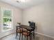 A compact office space with a desk, chairs, and a window overlooking greenery at 230 Seamarsh Ct, Atlanta, GA 30328
