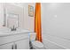 Stylish bathroom features a white vanity, toilet, and a shower with vibrant orange curtain at 351 Boundless Ln, Canton, GA 30114