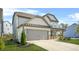 View of the house focusing on the spacious two-car garage, long driveway, and tidy landscaping at 351 Boundless Ln, Canton, GA 30114