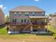 Spacious backyard featuring a two-story deck, a large grassy area, and mature landscaping at 5115 Edgebrook Dr, Cumming, GA 30040