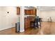 Stylish bar area with wooden cabinets, wine storage, sink, and bar stool seating on hardwood floors at 5115 Edgebrook Dr, Cumming, GA 30040