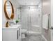 Beautifully remodeled bathroom with marble tile shower, gray tile floor, and modern vanity with wood-trimmed mirror at 5115 Edgebrook Dr, Cumming, GA 30040
