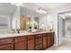 Bathroom showing granite countertops, wooden cabinets, and a framed mirror above the double sinks at 5115 Edgebrook Dr, Cumming, GA 30040