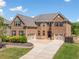 Elegant two-story brick home with a well-manicured lawn, spacious driveway, and a three-car garage at 5115 Edgebrook Dr, Cumming, GA 30040