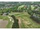 Lush green golf course community with residential homes and serene water feature from an aerial perspective at 5309 Davenport Mnr, Cumming, GA 30041