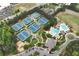 Aerial view of community with tennis courts, a pool, parking, and a playground surrounded by trees at 5309 Davenport Mnr, Cumming, GA 30041