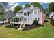 Exterior view of the home from the backyard with a spacious deck, well-maintained lawn, and mature trees at 5309 Davenport Mnr, Cumming, GA 30041