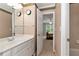 This bathroom features a large mirror with dual clocks and a doorway into the bedroom at 5309 Davenport Mnr, Cumming, GA 30041