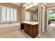 Bathroom with a soaking tub, wallpaper, and vanity with views to sunroom at 5309 Davenport Mnr, Cumming, GA 30041