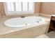 Close up of a soaking tub with jets and decorative tile surround at 5309 Davenport Mnr, Cumming, GA 30041