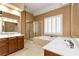 Bathroom with a soaking tub, vanity, wallpaper, and glass-enclosed shower at 5309 Davenport Mnr, Cumming, GA 30041