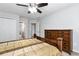 Spacious bedroom with a ceiling fan, generous closet space, wooden furniture and a view into an ensuite bathroom at 5309 Davenport Mnr, Cumming, GA 30041