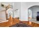 Elegant foyer with a curved staircase, hardwood floors, and arched doorways at 5309 Davenport Mnr, Cumming, GA 30041
