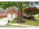 Beautiful brick home with well-manicured lawn, mature trees, and a two-car garage at 5309 Davenport Mnr, Cumming, GA 30041
